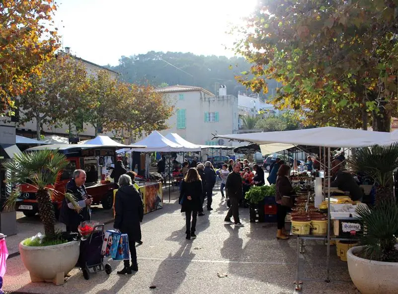 Visitors browsing outdoor market stalls in Capdepera
